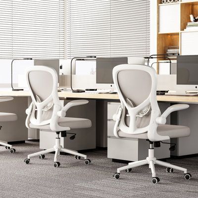 Close view of ergonomic keyboard, monitor arm, and adjustable chair in office